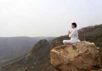 image تصویر آرامش بخش تمرین یوگا زنی بر روی صخره ها چین
